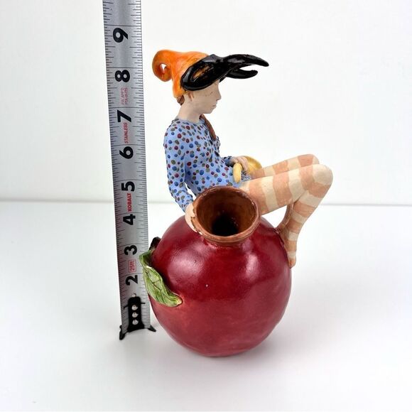 CARRIANNE L HENDRICKSON woman with beak hat sitting on apple sculpture 2… - Picture 15 of 16